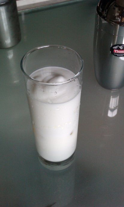 在杯中加入少量冰块,将牛奶倒入后再加上奶泡2