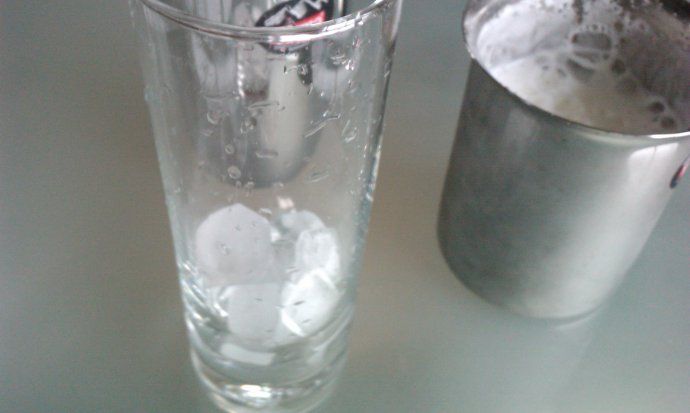 在杯中加入少量冰块,将牛奶倒入后再加上奶泡。