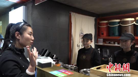 图为张杨和店员用手语交流。 张海雯 摄 图为张杨和店员用手语交流。 张海雯 摄
