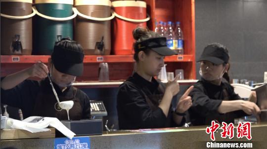 图为正在忙碌的咖啡店店员。 张海雯 摄 图为正在忙碌的咖啡店店员。 张海雯 摄